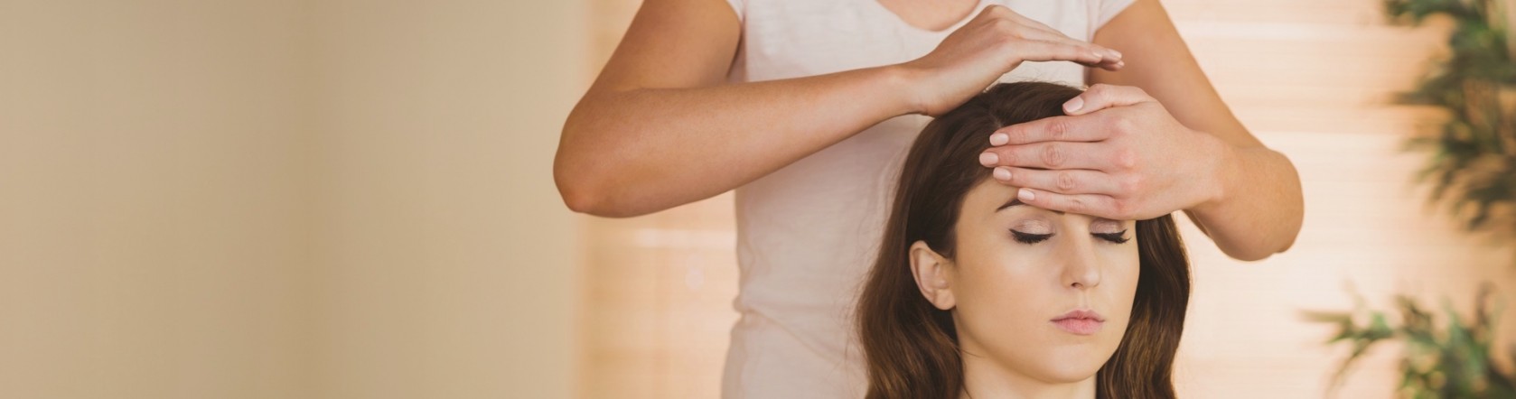 Reiki practitioner's hands hovering near a patient's shoulder during a gentle healing session